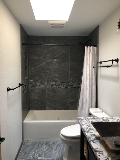 Jacuzzi tub with large format tiles and glass accent