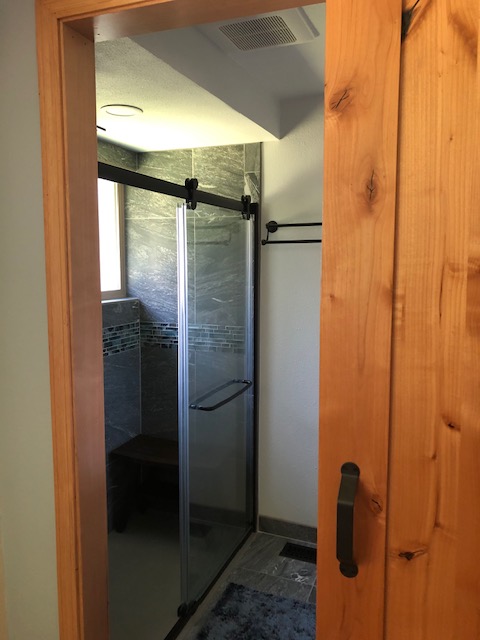 walk-in shower with custom tile and barn door